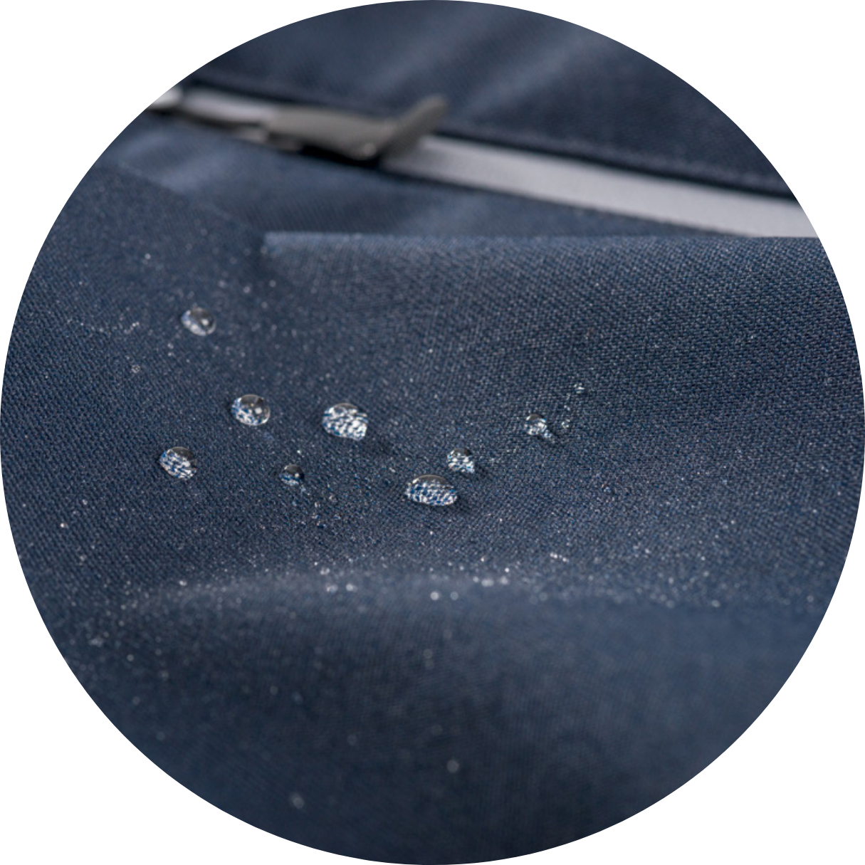 Water droplets beading on dark blue softshell fabric, zipper visible in background