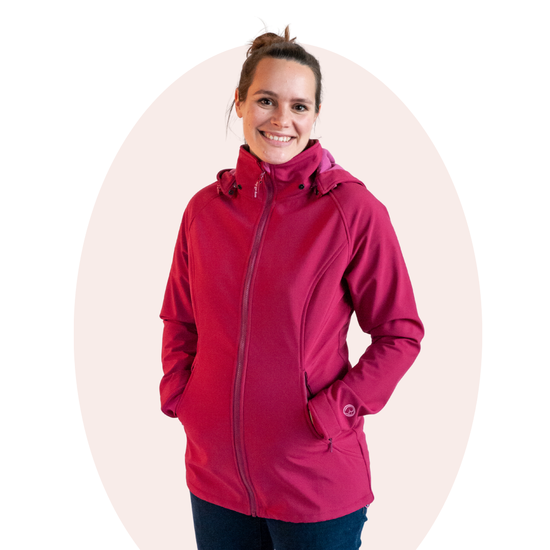 Woman wearing pink softshell jacket without baby, smiling, studio shot with light background